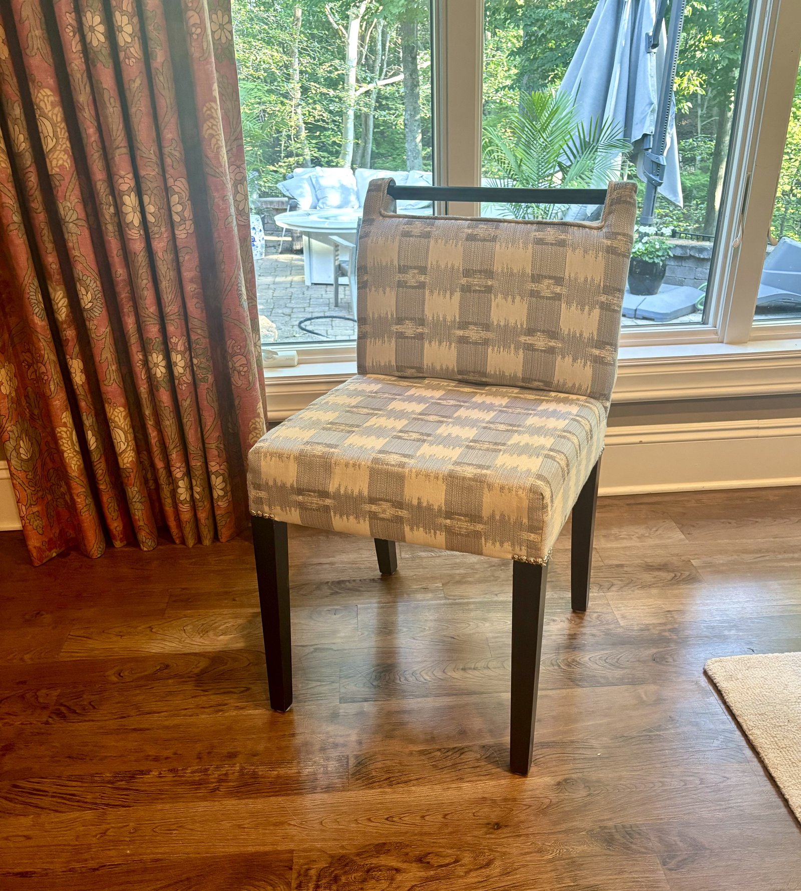 Handcrafted dining chair upholstered in a beige patterned fabric